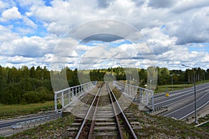 Railroad through highway track road. Bridge. Green grass. Forest. blue sky