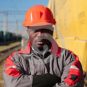Railroad man in uniform and red hard hat look at the camera
