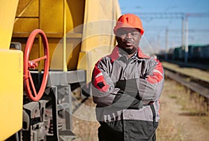 Railroad man in uniform and red hard hat look at the camera