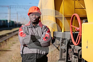 Railroad man in uniform and red hard hat look at the camera