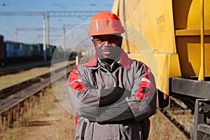 Railroad man in uniform and red hard hat look at the camera