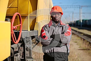 Railroad man in uniform and red hard hat look at the camera