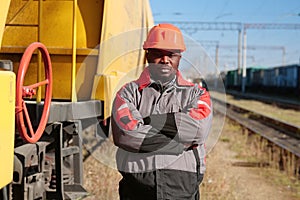 Railroad man in uniform and red hard hat look at the camera