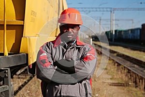 Railroad man in uniform and red hard hat look at the camera