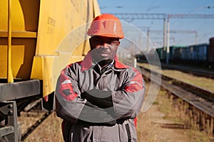 Railroad man in uniform and red hard hat look at the camera