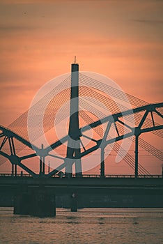 railroad metal bridge silhouette over river of Daugava in Riga,