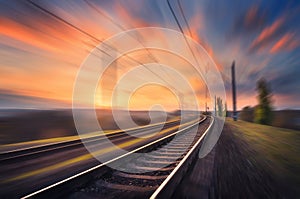 Railroad in motion at sunset. Blurred railway station