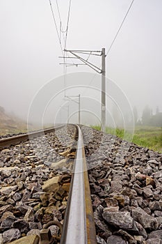 Railroad in the nature on a foggy morning