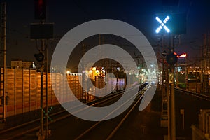 Railroad night scene with blue traffic light and railway station tracks, at dusk, golden tones and colors. Industrial