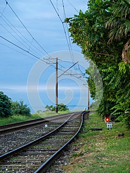 Railroad on the outskirts of the city. Road for electric transport among the trees. Sleepers and rails. Concept of path and