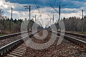 Railroad Rails going into the distance. Pillars, wires, railway arrows