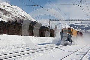 Railroad snowthrower removing snow from railway photo