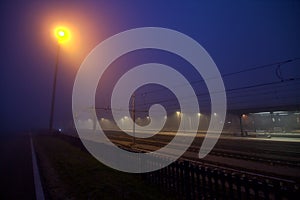 Railroad station at sunset on a foggy day seen from the distance