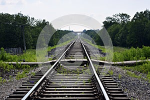 Railroad in the summer in the countryside. Rails and sleepers. Road for freight and passenger trains