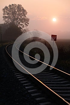 Railroad track during autumn foggy morning