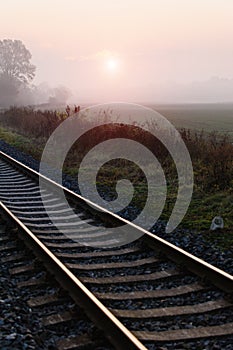 Railroad track during autumn foggy morning