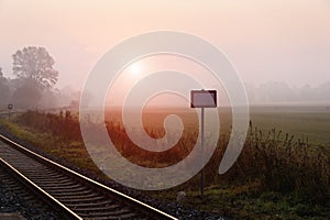 Railroad track during autumn foggy morning