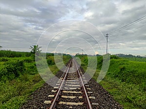 Railroad track near green countryside