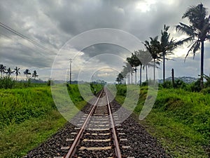 Railroad track near green countryside