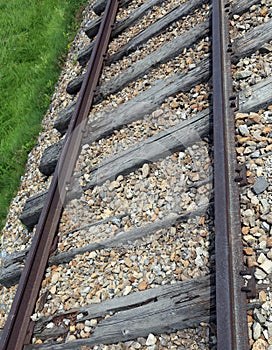 Railroad track with the roadbed in rocks and rusty rails photo