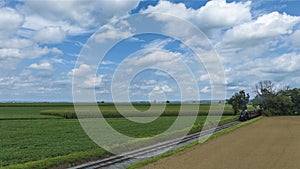 Railroad Tracks Curve Gently Through A Lush Agricultural Landscape With Fields Of Various Shades