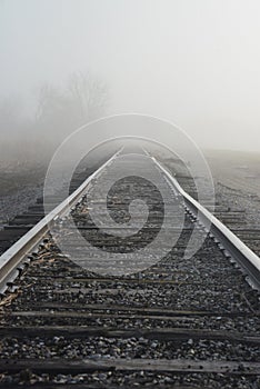 Railroad tracks fading into the misty morning light.