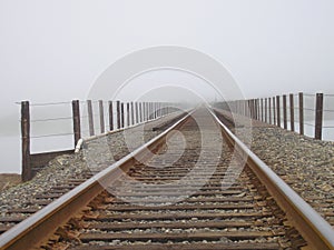 Railroad tracks into fog