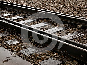 Railroad tracks in heavy rain, water reflections abstract. Wet train tracks, water on railway closeup, detail. Sad, melanholic