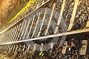 railroad tracks, metal rails, concrete sleepers in sunlight, engineered structures with guide rail track, concept of cargo
