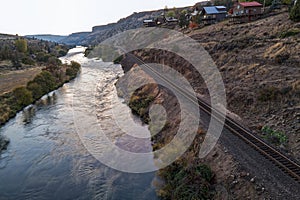 Railroad tracks run adjacent to the Deschutes River as the sun sets on the town of Maupin, Oregon, USA