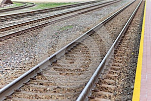 Railroad tracks urban shoot. Leading line view.iron rusty train railway over dark stones rail way