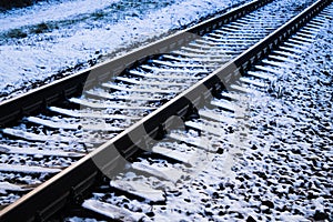 Railroad tracks in a winter foggy morning sprinkled with snow