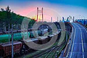 Railroad transportation, freight cars in industrial seaport at sunset