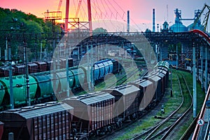 Railroad transportation, freight cars in industrial seaport at sunset