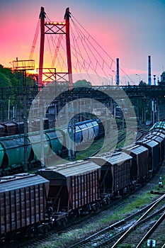 Railroad transportation, freight cars in industrial seaport at sunset