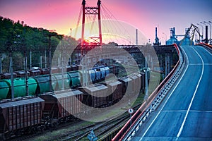 Railroad transportation, freight cars in industrial seaport at sunset