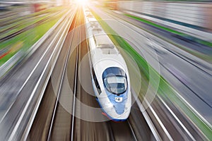 Railroad travel passenger train with motion blur effect, industrial a district of the city, top aerial view from above