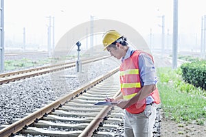 Railroad worker in protective work wear checking the railroad tracks