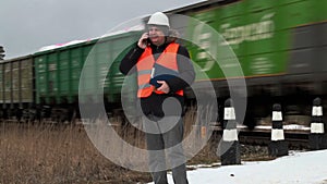 Railroad worker talking on smart phone near railway crossing