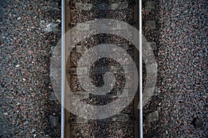 Rails and cross ties of railway among stones