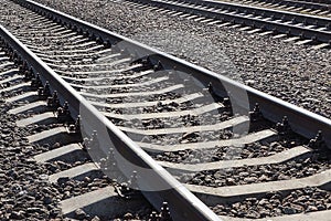 Rails and sleepers in gray stones and rubble on the railroad