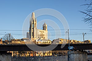 Railway bridge on the background of the Church of St. Felix in Girona at sunset, Spain, Catalonia