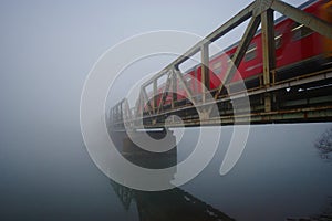 Railway Bridge With Red Train In The Fog