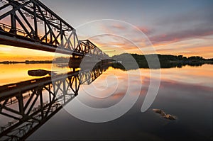 Railway bridge of steel construction in the light of the setting sun