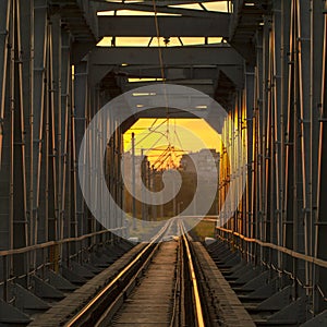 railway bridge of steel structures, on a sunset background