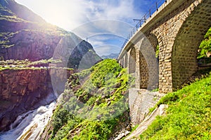 Railway bridge Teufelsbrucke over Reuss river in St. Gotthard mountain range of Swiss Alps near Andermatt