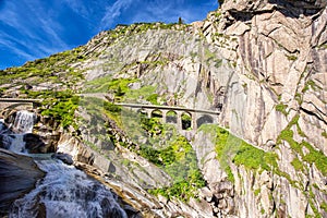 Railway bridge Teufelsbrucke over Reuss river in St. Gotthard mountain range of Swiss Alps near Andermatt