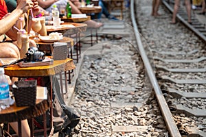 Railway cafe. People drink coffee or walking on railways waiting for train to arrive on railway road in Hanoi, Vietnam