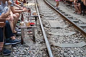 Railway cafe. People drink coffee or walking on railways waiting for train to arrive on railway road in Hanoi, Vietnam