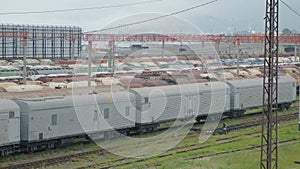 Railway cargo wagons on railroad. Depot of freight trains. Freight station with oil or fuel tanks for transportation by